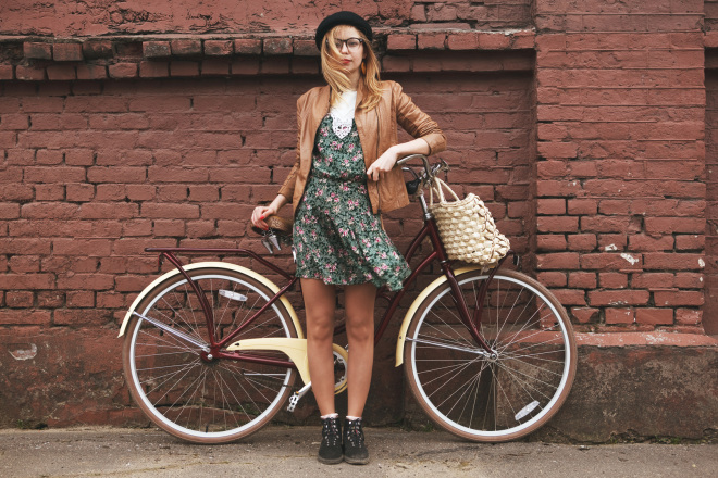 fashionable woman with vintage bike on brick wall background